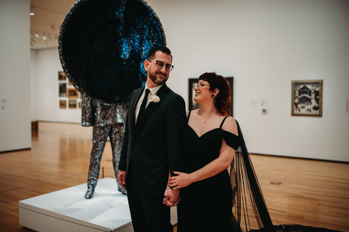 Bride holds groom in front of art installation in Akron
