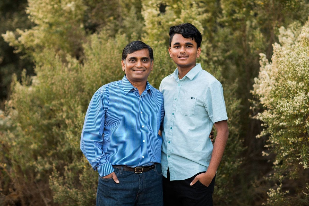 Father and son pose together amongst the green bushes at a nearby walking trail