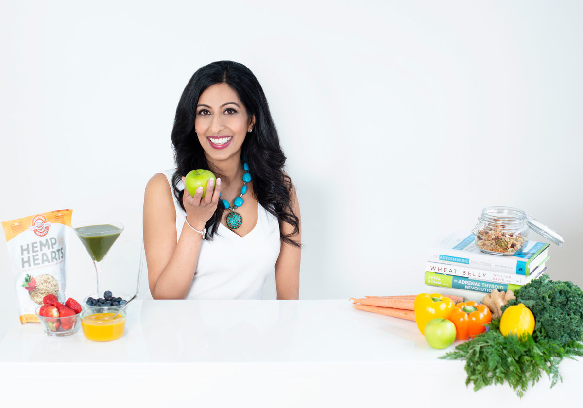 nutition and  wellness coach personal branding photograhy session sittin ondesk showing  fesh  fruits and  vegetables
