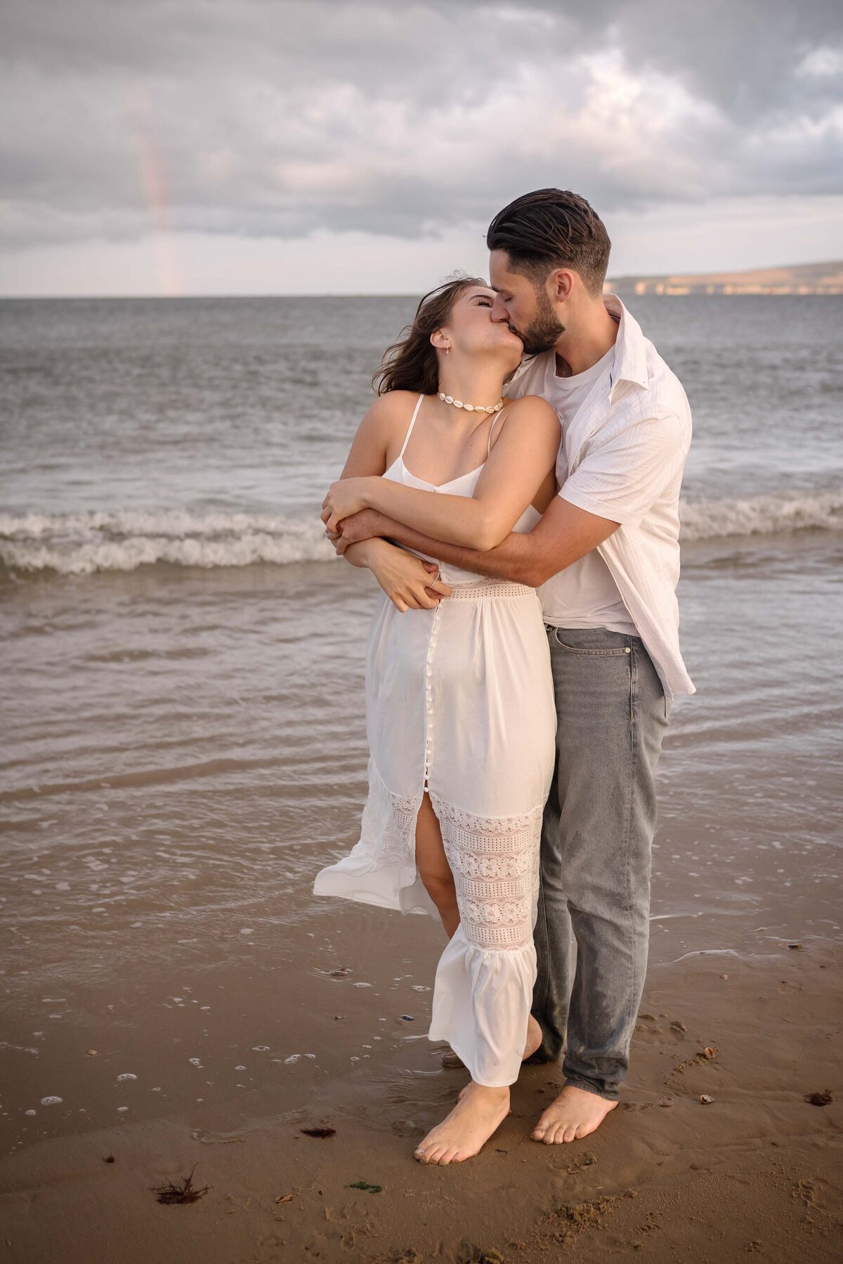 A couple on the seashore kissing near the water