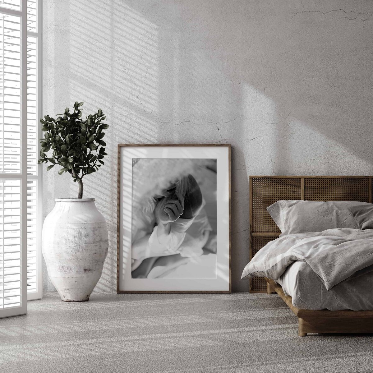 Et sort rammet bilde fra boudoirfotografering.i Oslo står på gulvet i et soverom.