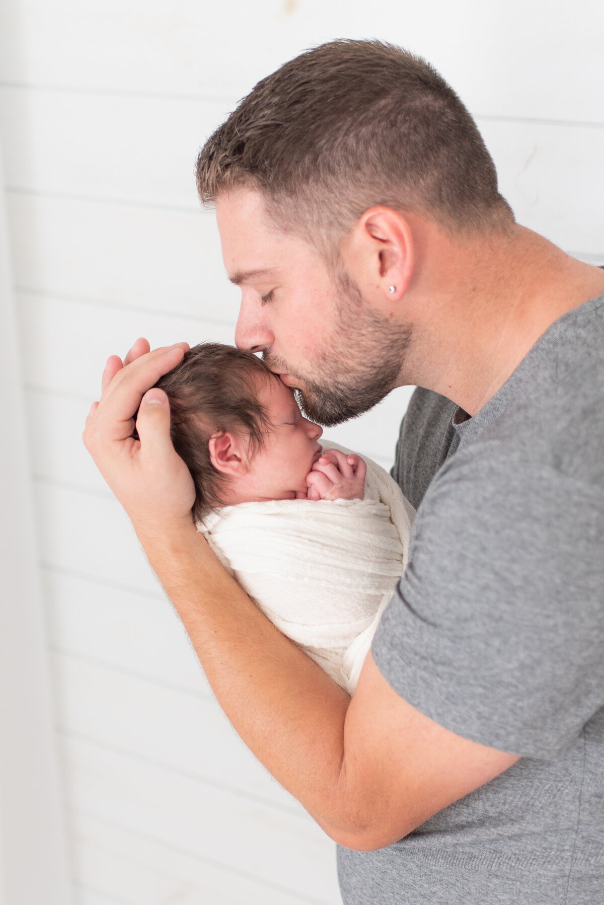 Father kissing newborn son