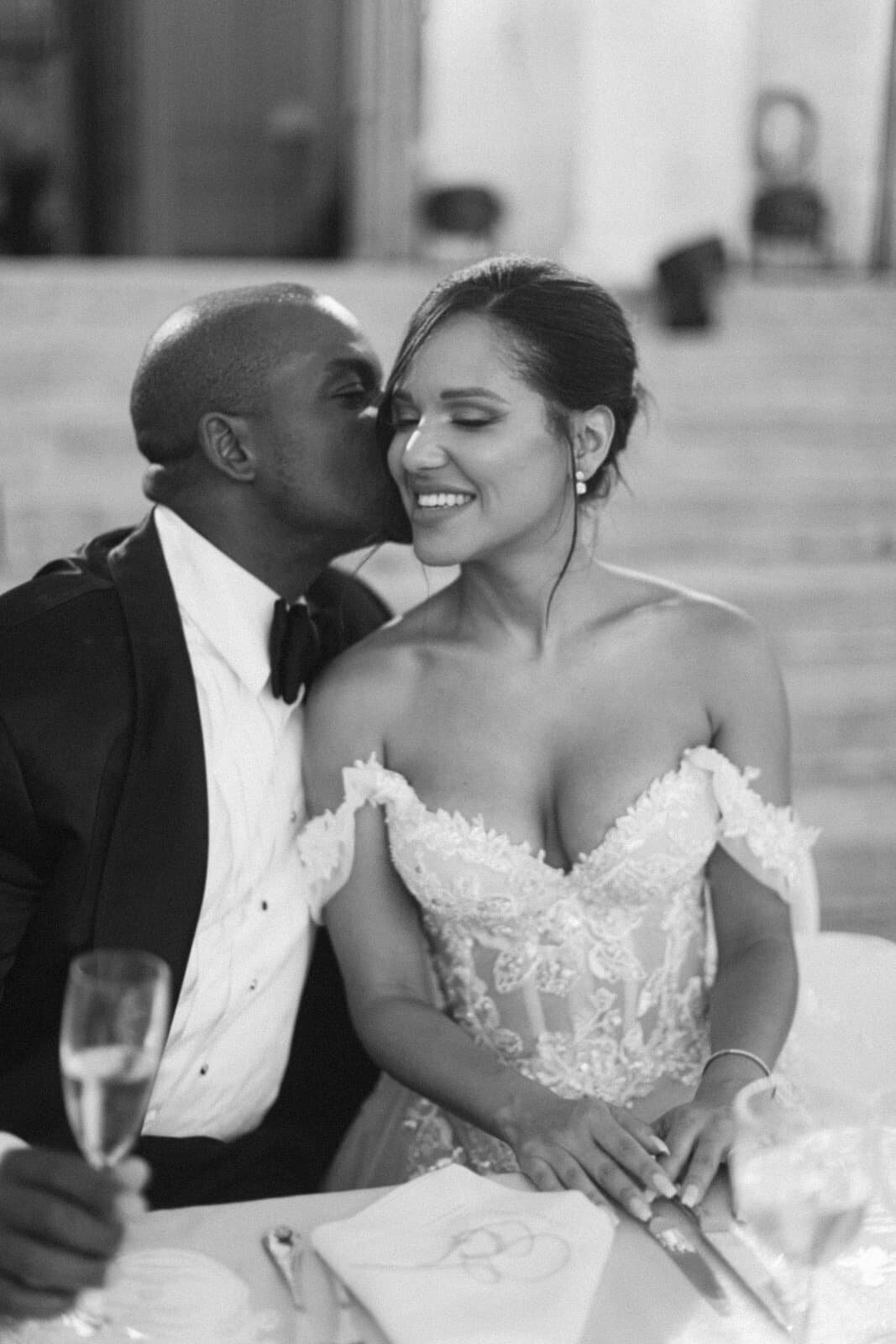 Romantic black and white portrait of the groom kissing the bride at the reception, by Paris wedding photographer Thomas Raboteur