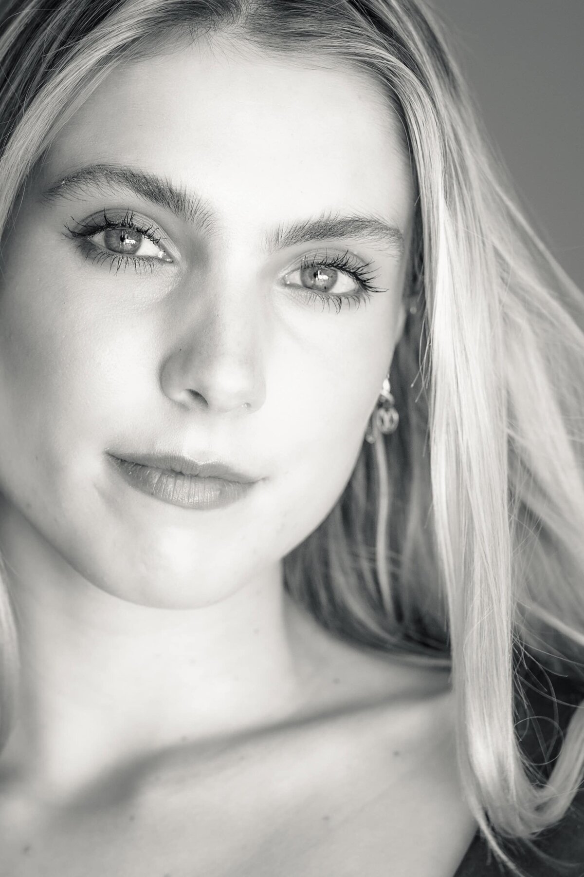 Black and white close up headshot of a beautiful young woman with long hair