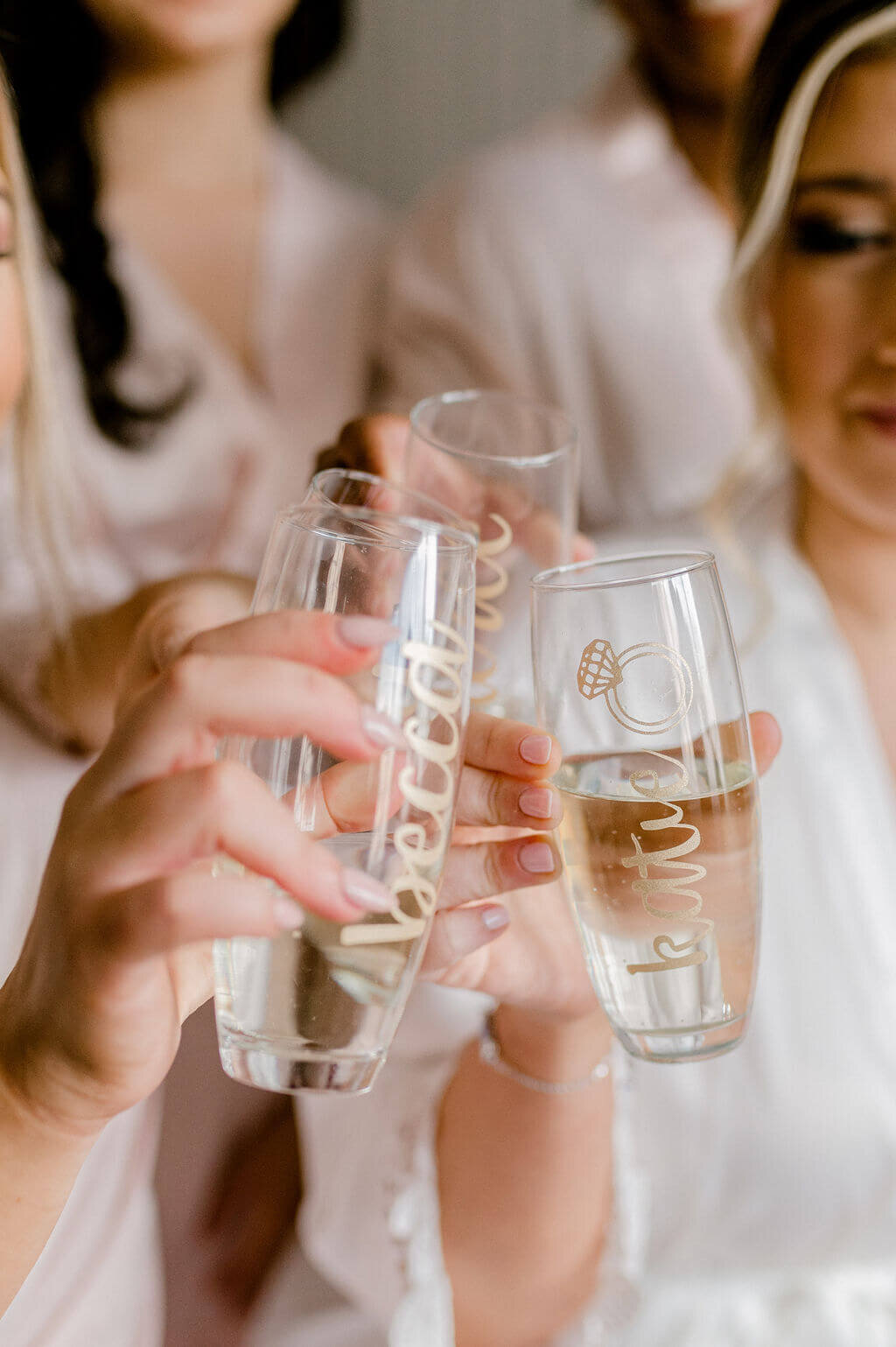 Classic image of bride and bridesmaids tipping glasses together.
