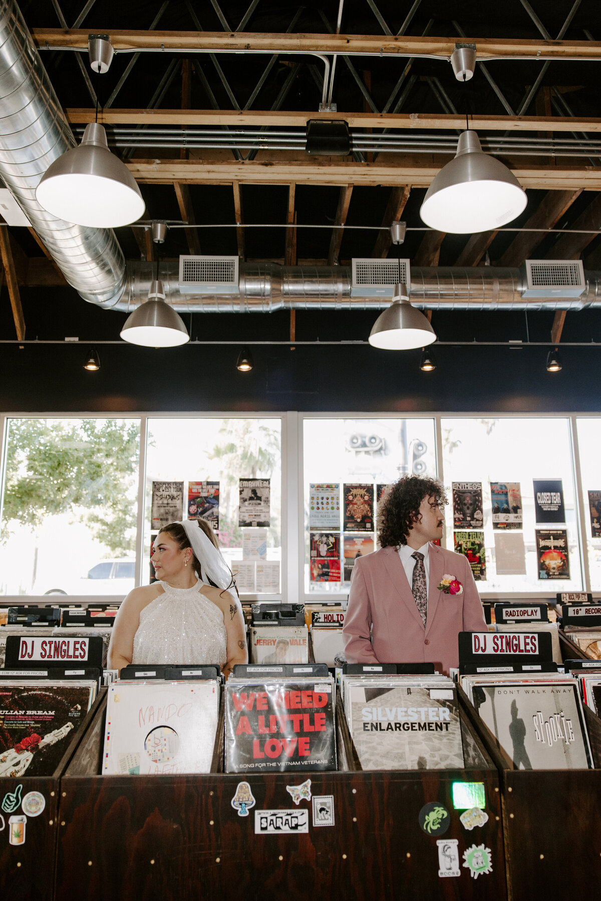 Two people look in opposite directions in a record shop.