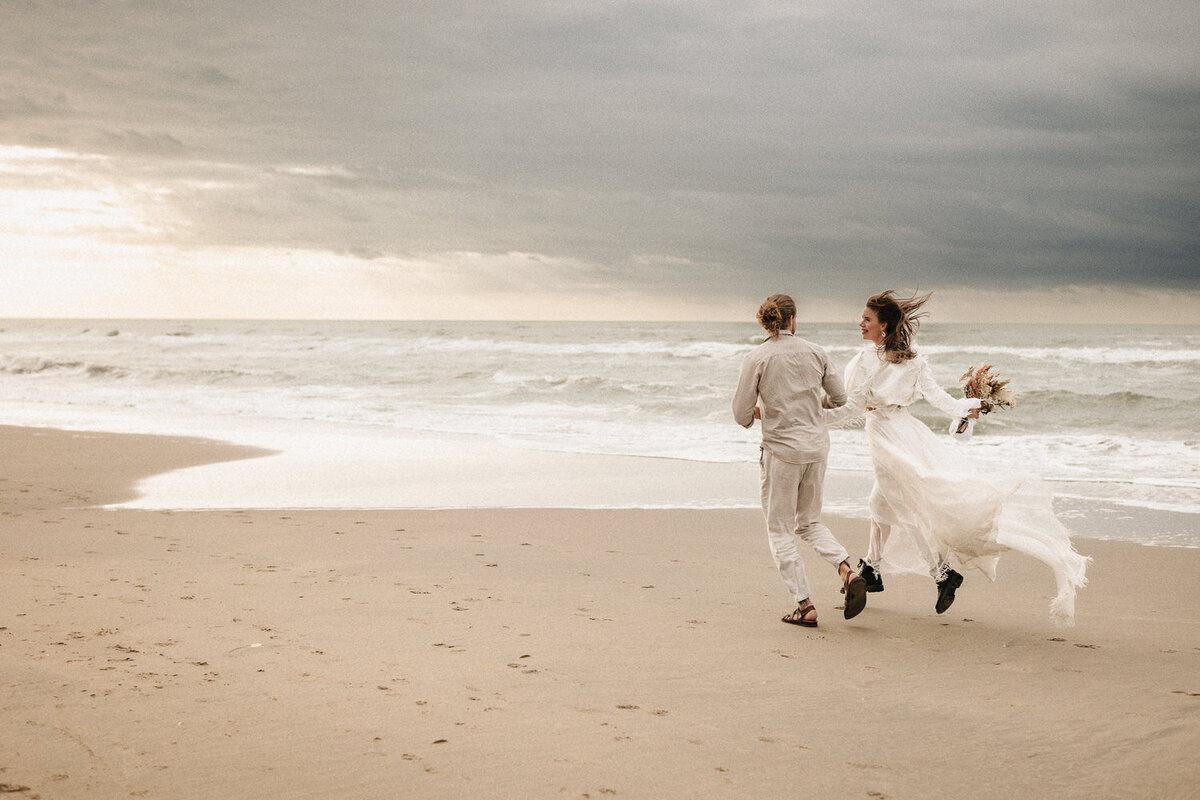 Brautpaar rennt am Strand von Nordwijk in Holland