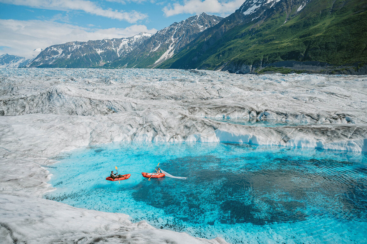 Couple kayak in glacier pool