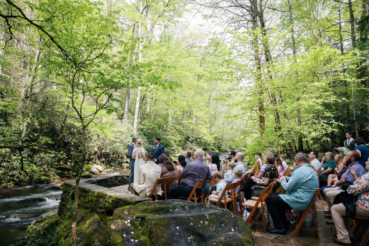 Spence Cabin outdoor ceremony with bride and groom holding hands and listening to their officiant during their Gatlinburg elopement