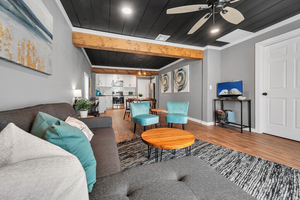 Sleeper sofa in the open concept living, dining, and kitchen at this two-bedroom, one-bathroom vacation rental house for five located just 5 minutes from Magnolia, Baylor, and all things downtown Waco.