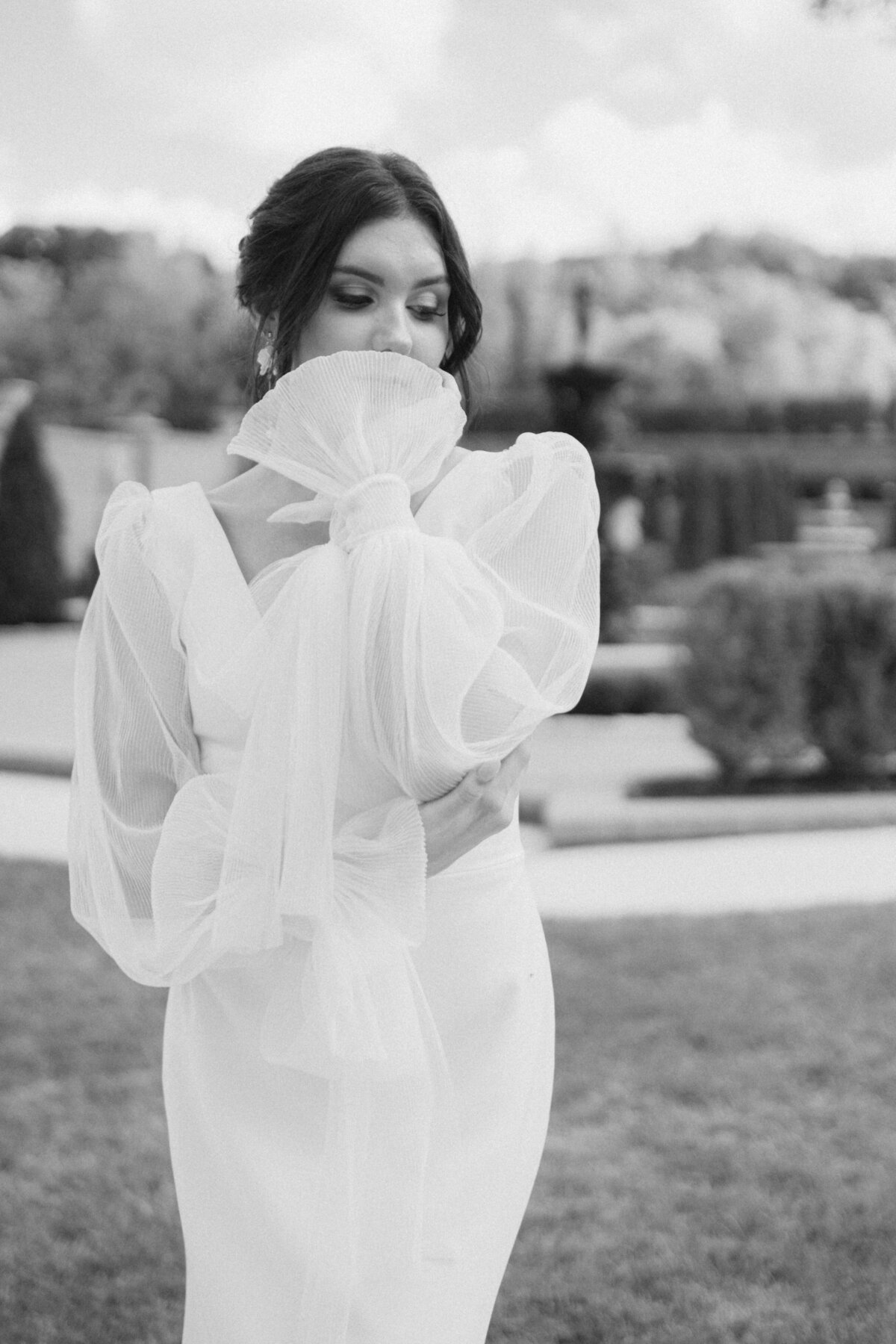 Black and white bridal portrait with sheer puff sleeves in elegant garden setting