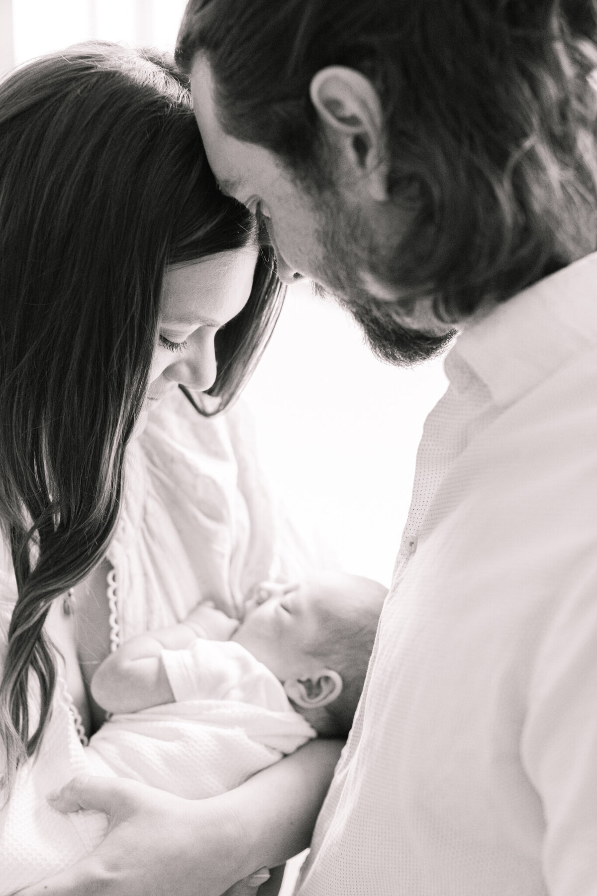 close up black and white photograph of new parents holding their baby taken by newborn photographer in boston