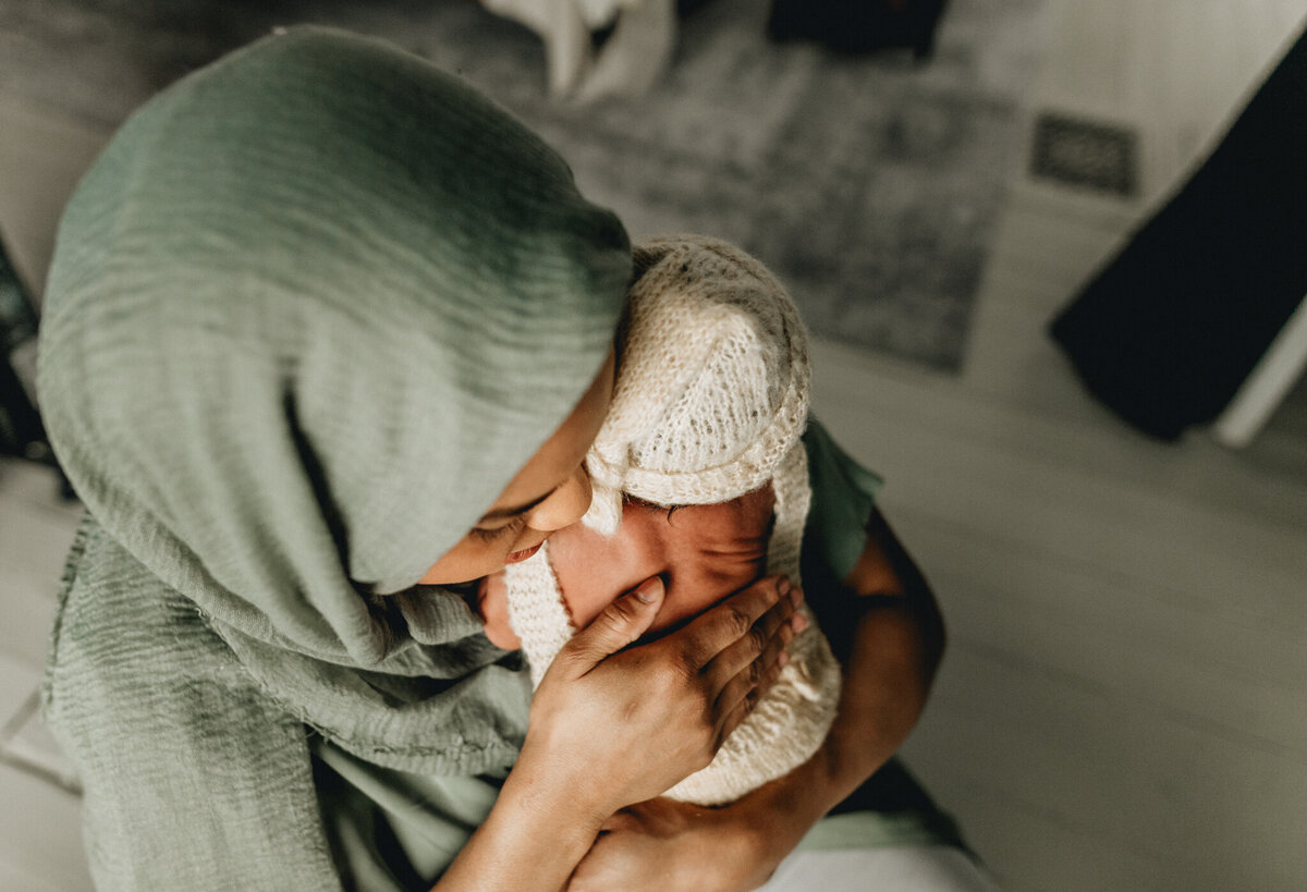 Newborn photographer capturing mom holding infant babe