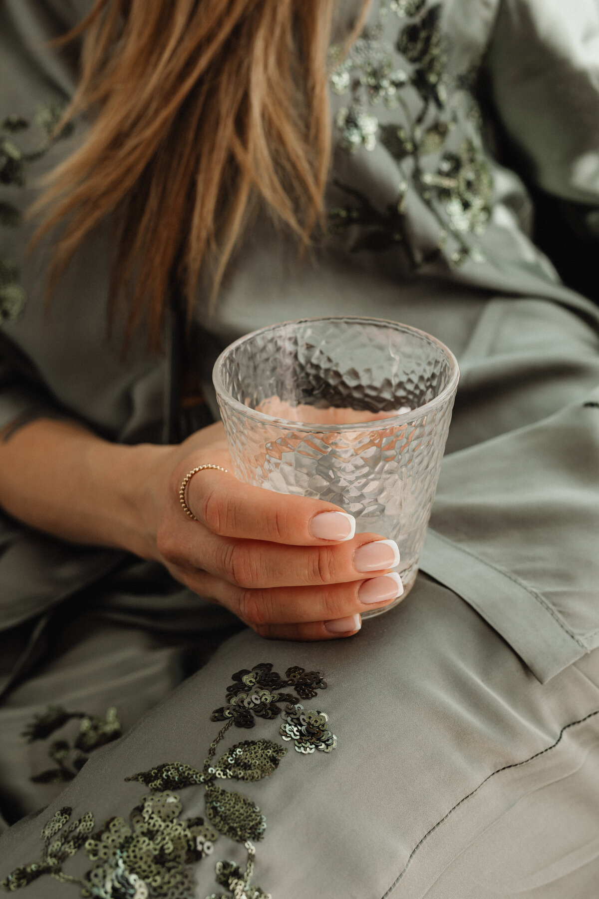 kaboompics_woman-in-satin-ensemble-with-french-manicure-holding-a-glass-of-water-32277
