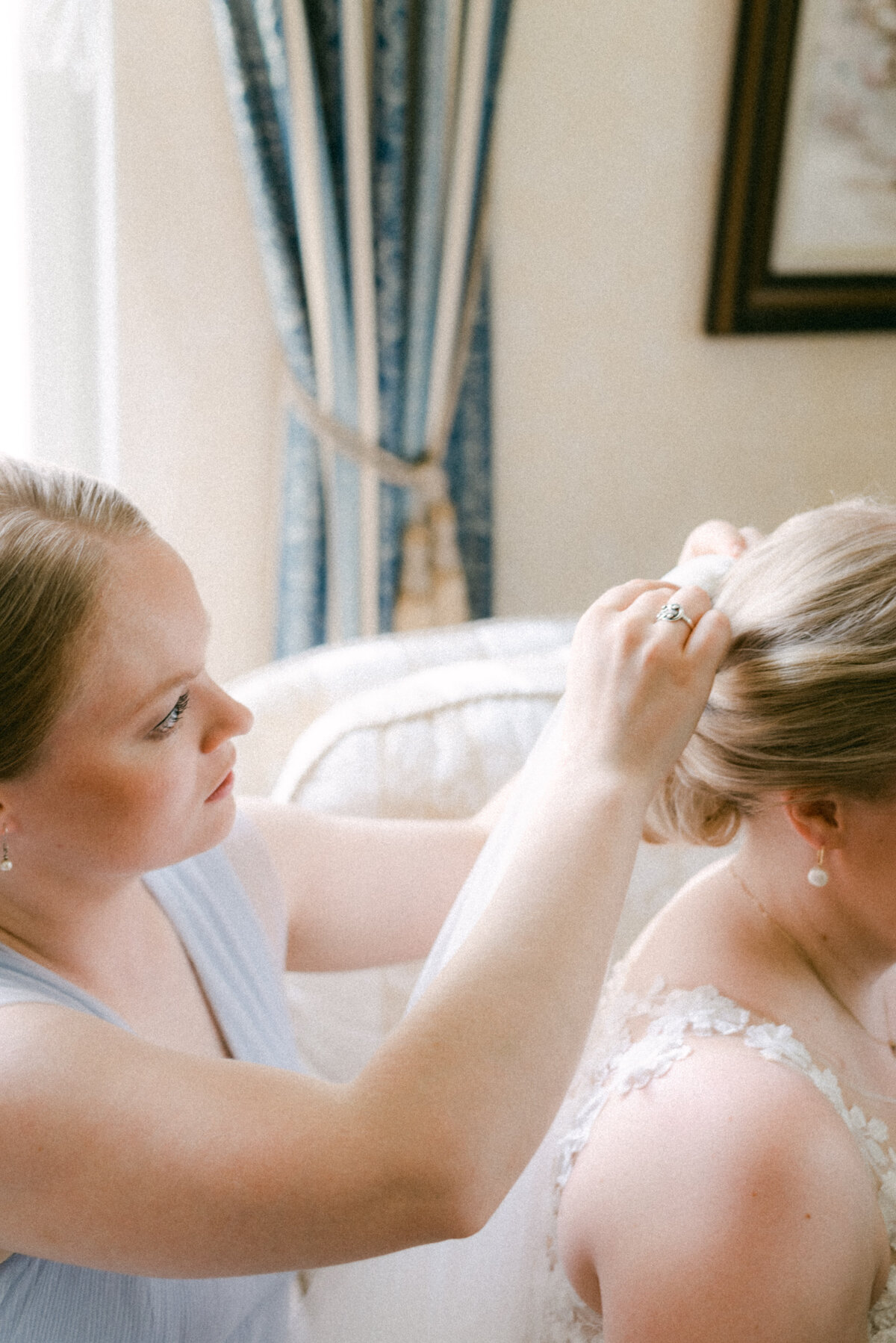 The bridesmaid helping in putting on the veil in an image photographed by wedding photographer Hannika Gabrielsson.