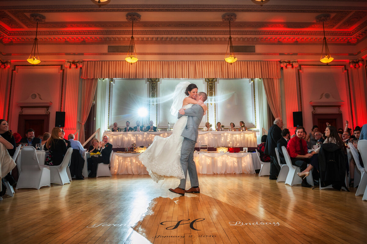 Groom picks up bride during first dance at reception.