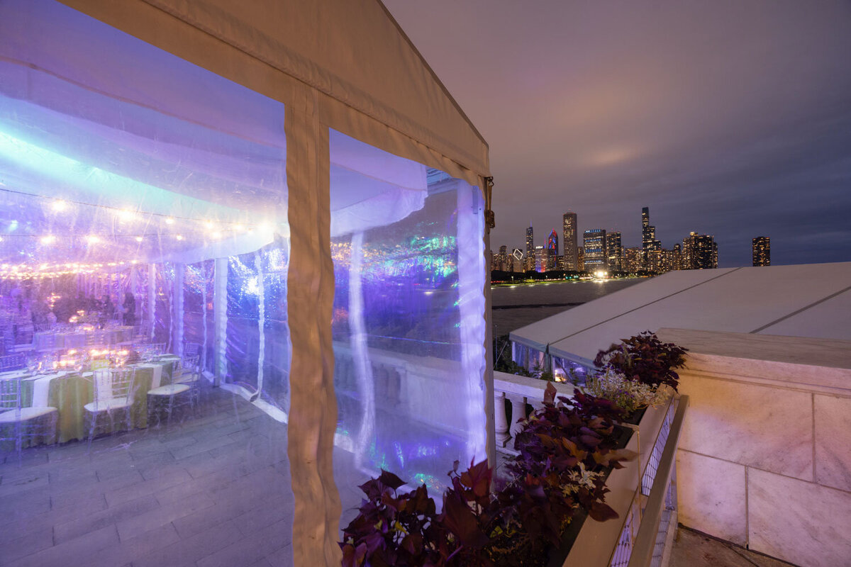 Tent with city skyline view through transparent wall at night