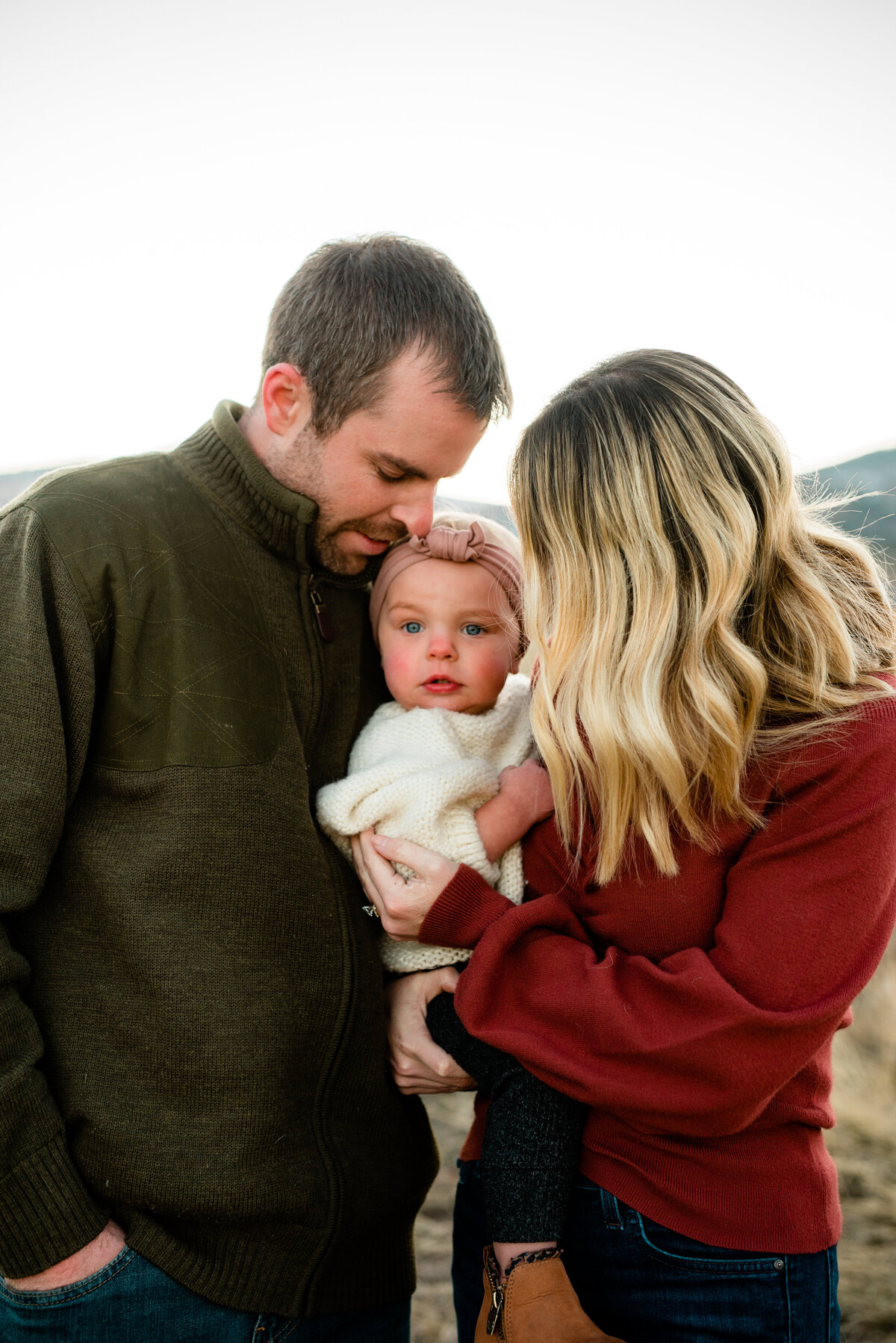 family holding their new daughter in the fall in colorado