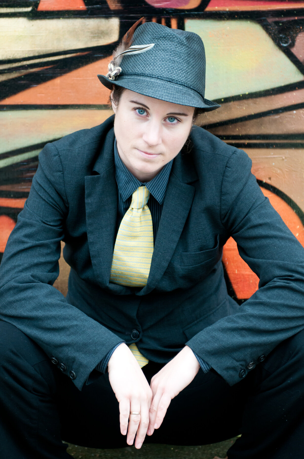 a person in a suit and fedora sitting on the ground