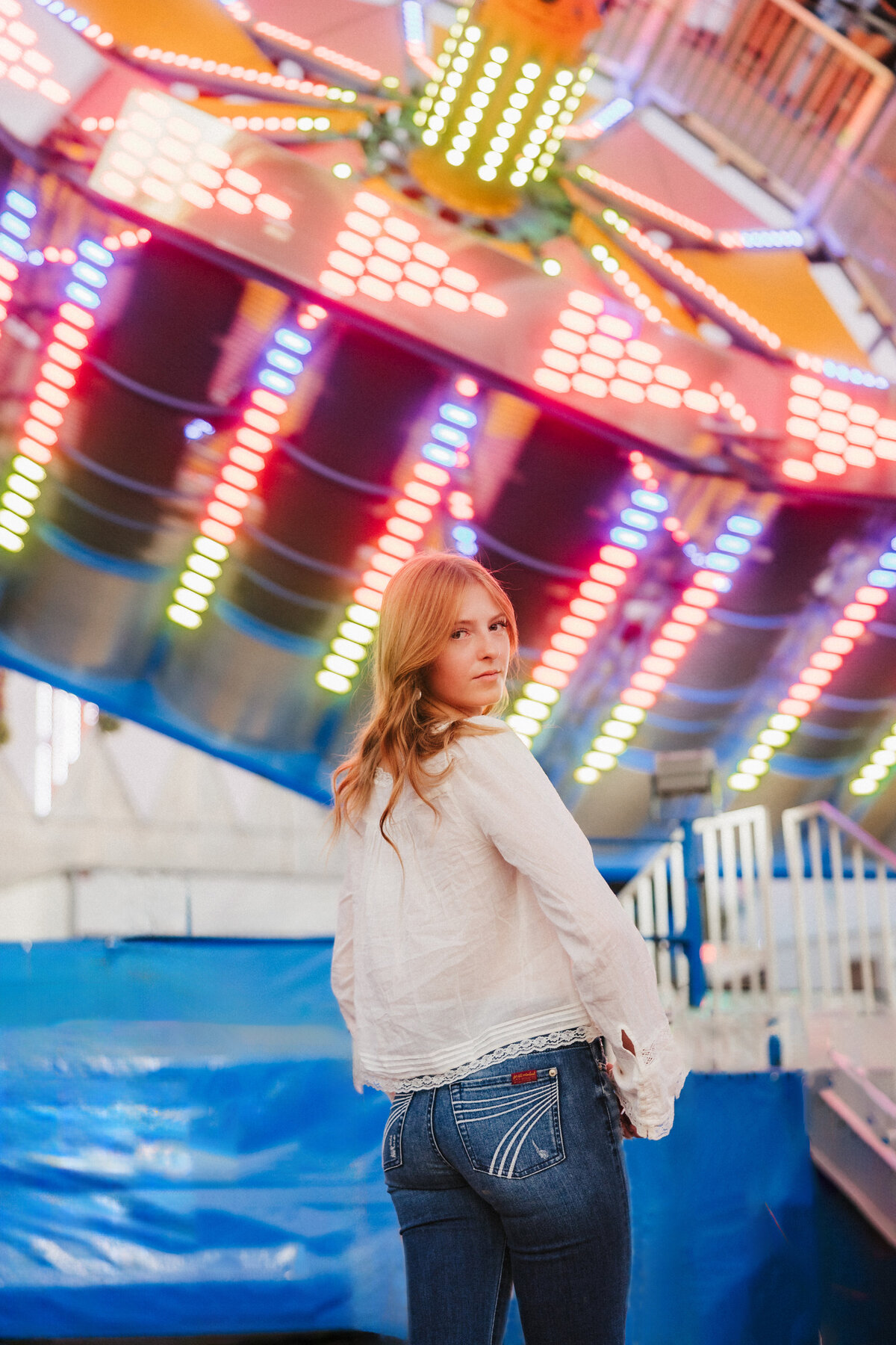 Senior poses on a carnival ride