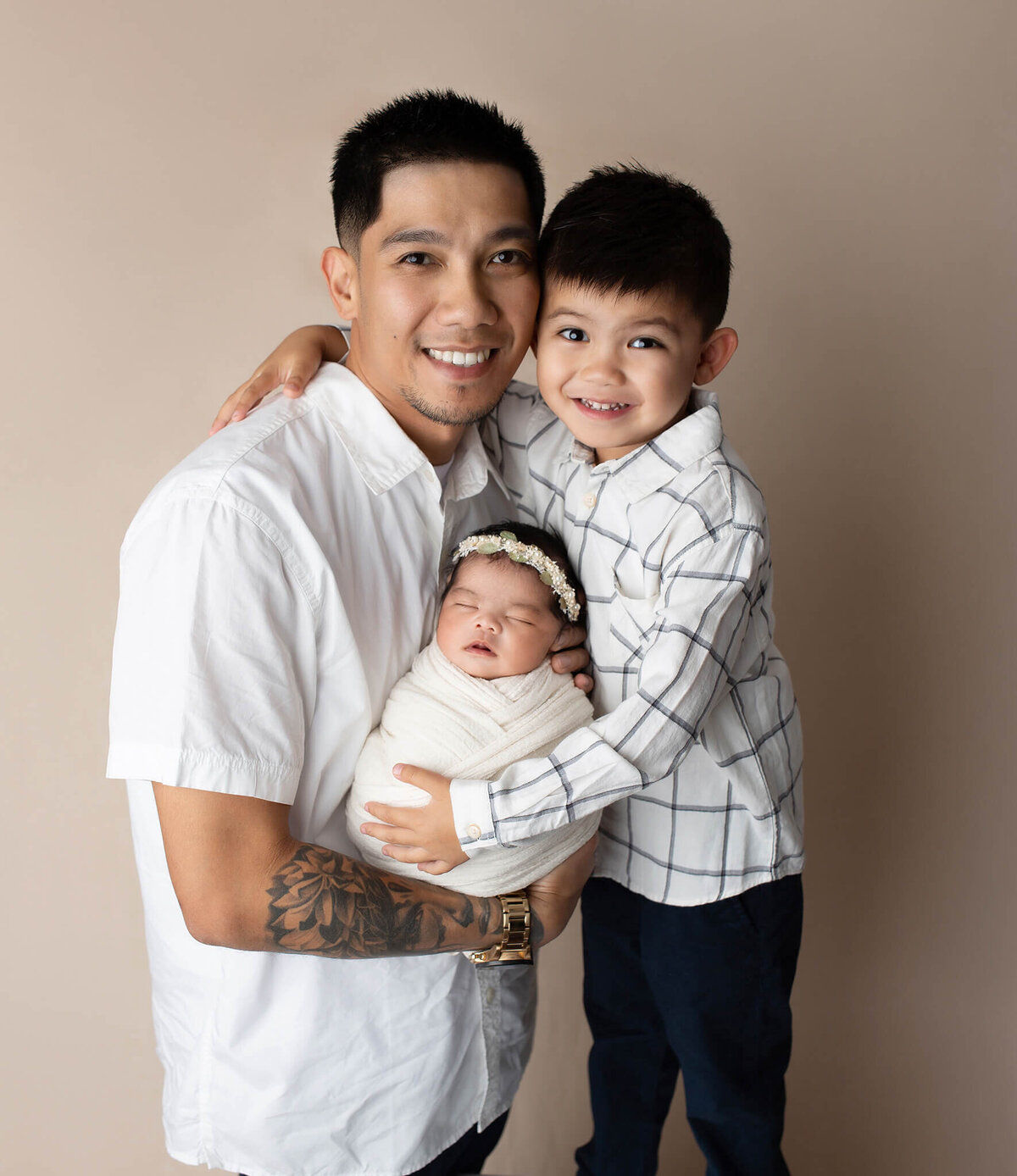 portrait of dad with older son and newborn baby girl