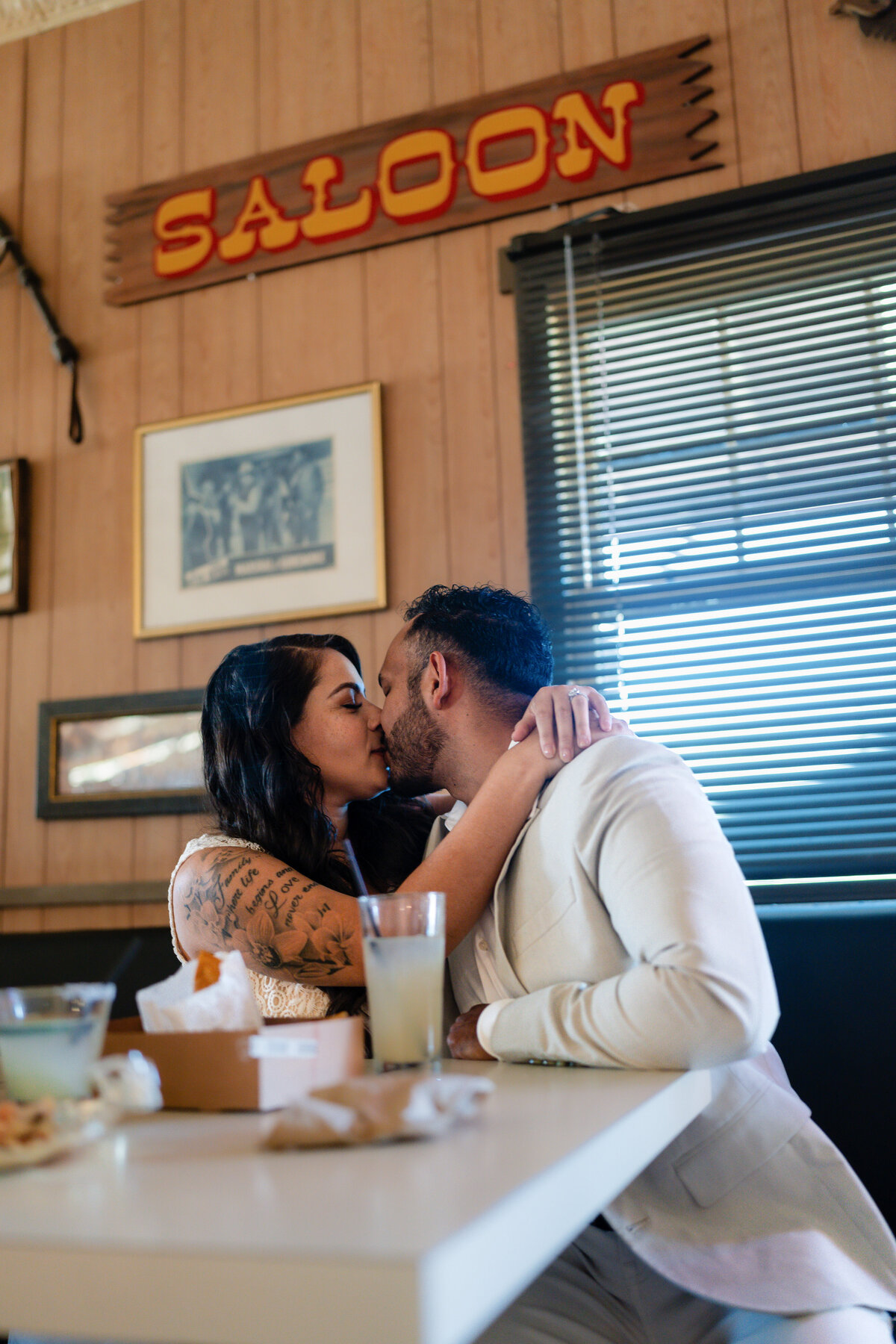 Joshua Tree elopement with bride and groom having lunch and kissing inside Red Dog Saloon.