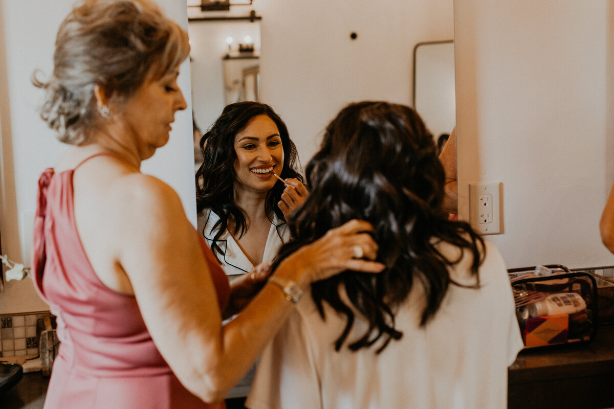two brides getting ready for their wedding together with their moms