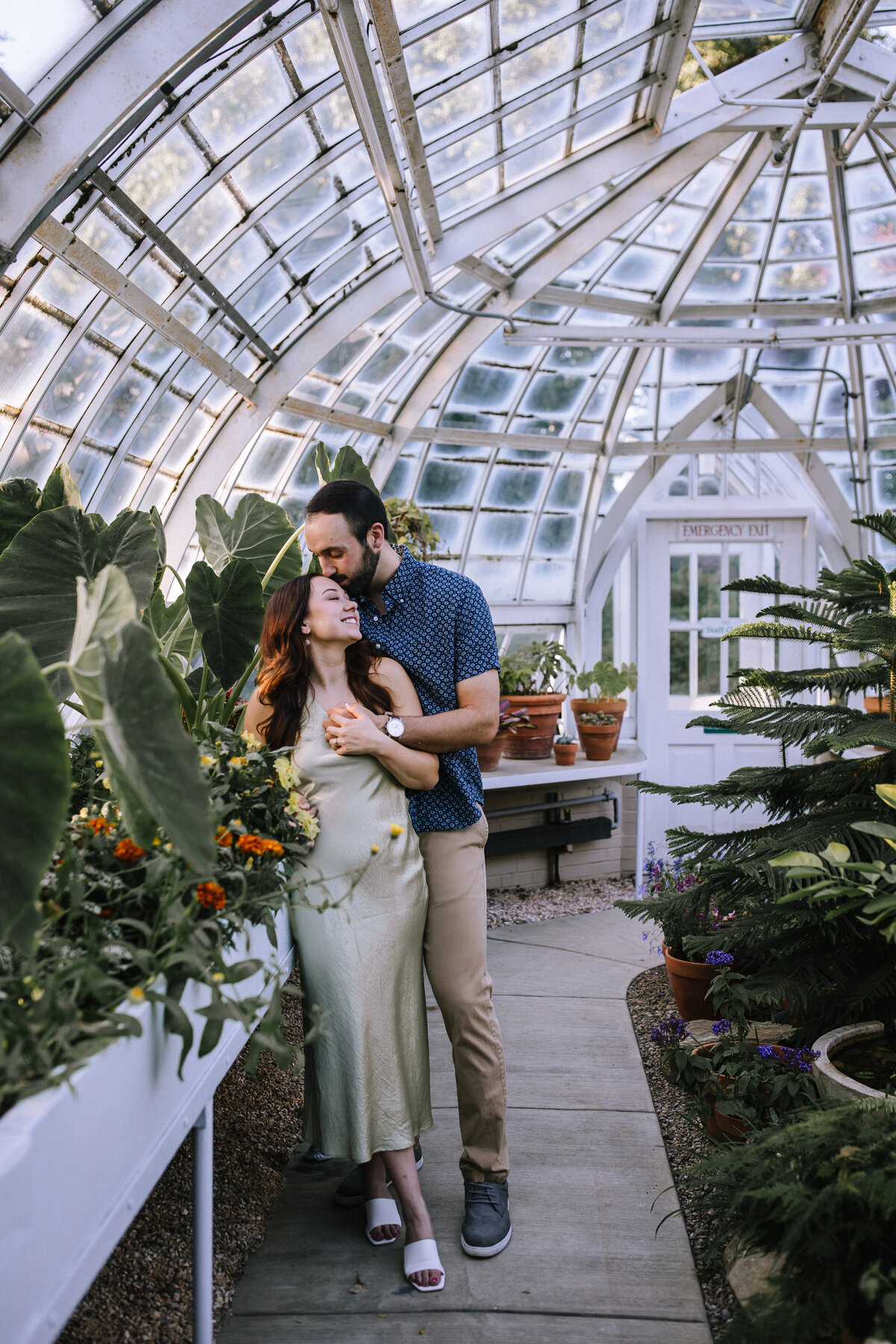 Engaged couple in a greenhouse at The Frick. 