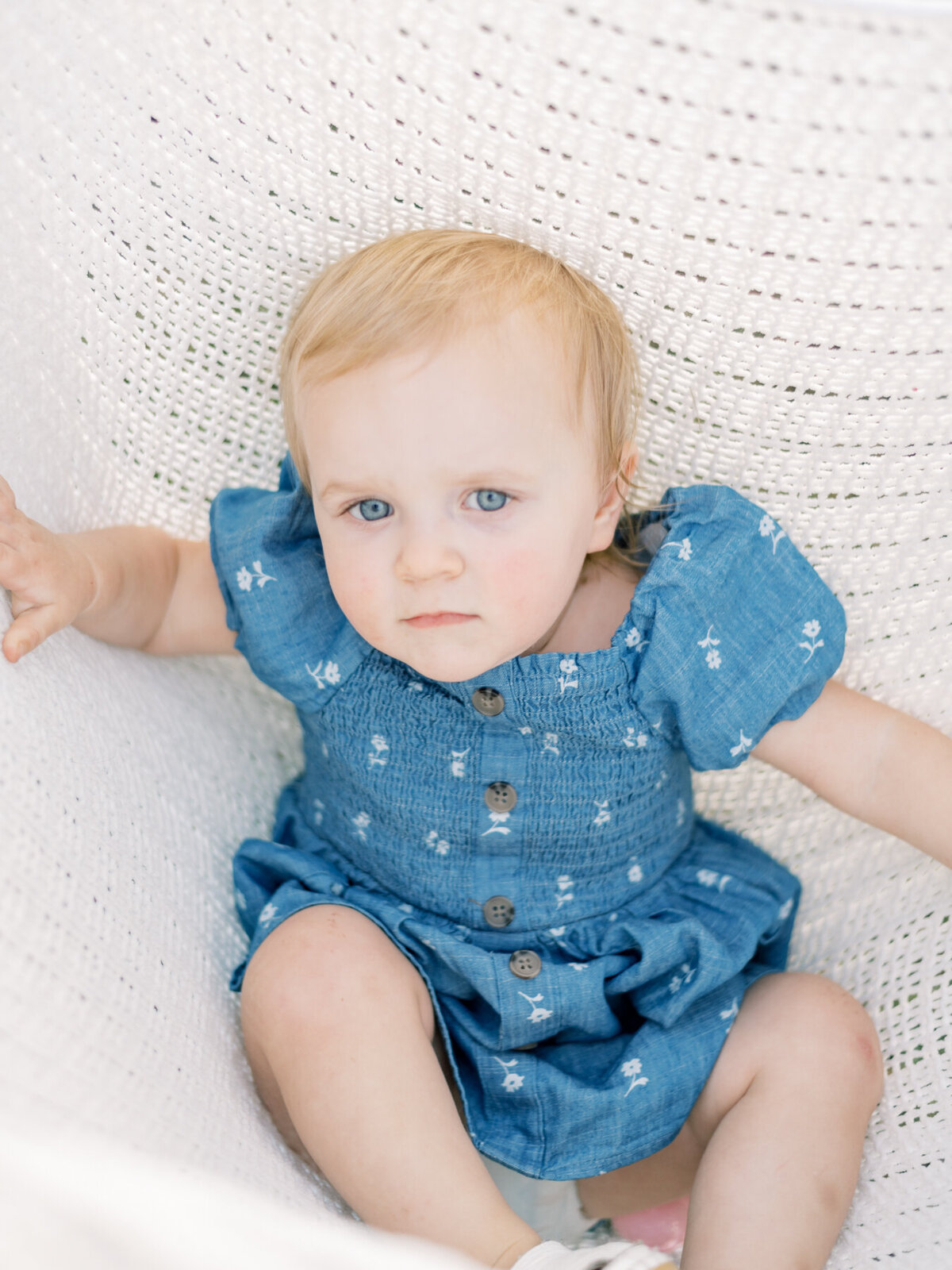 Beautiful young daughter laying on white blanket.