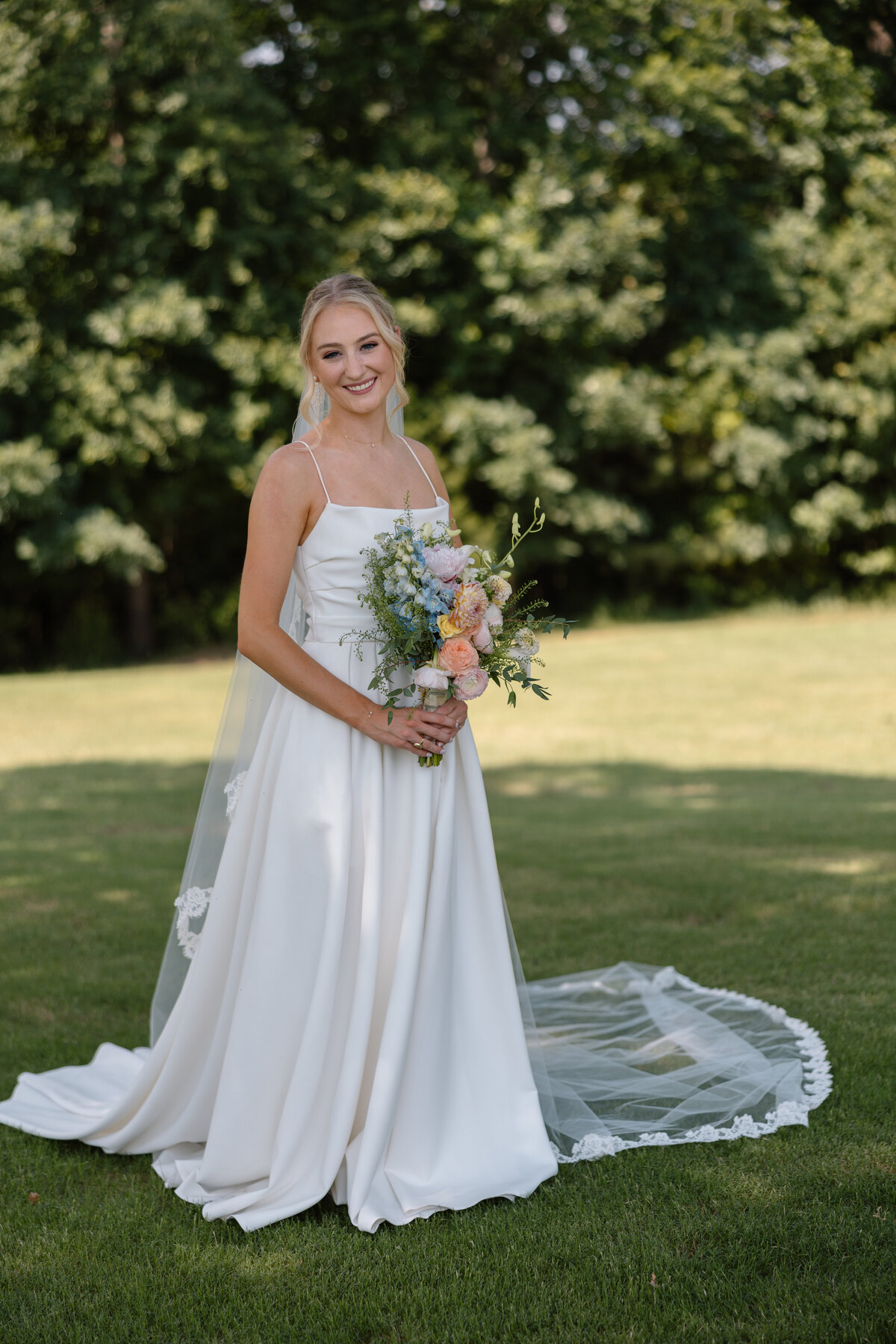 Bride smiles are she holds her bouquet