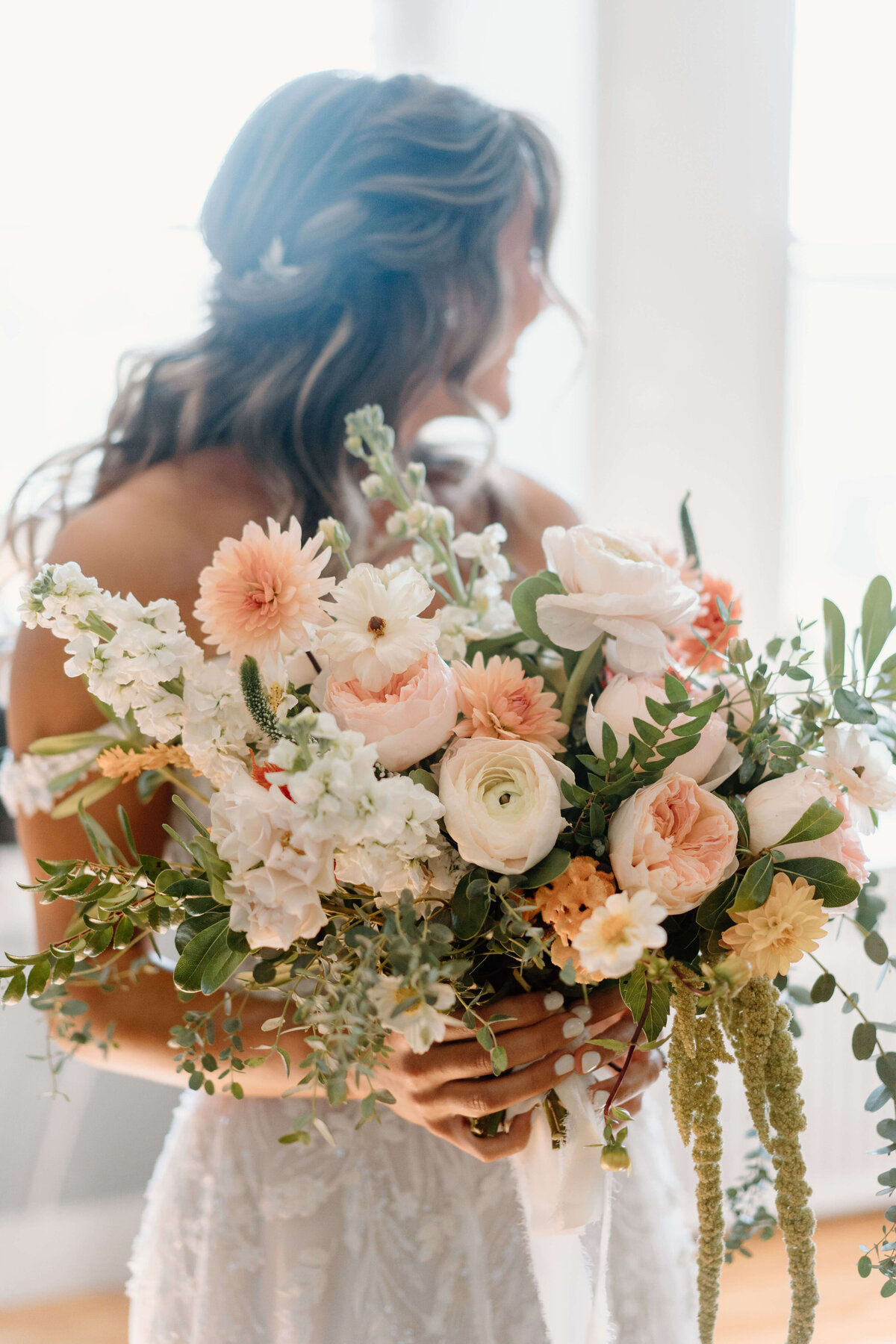 large bridal bouquet with pale orange, white florals and greenery