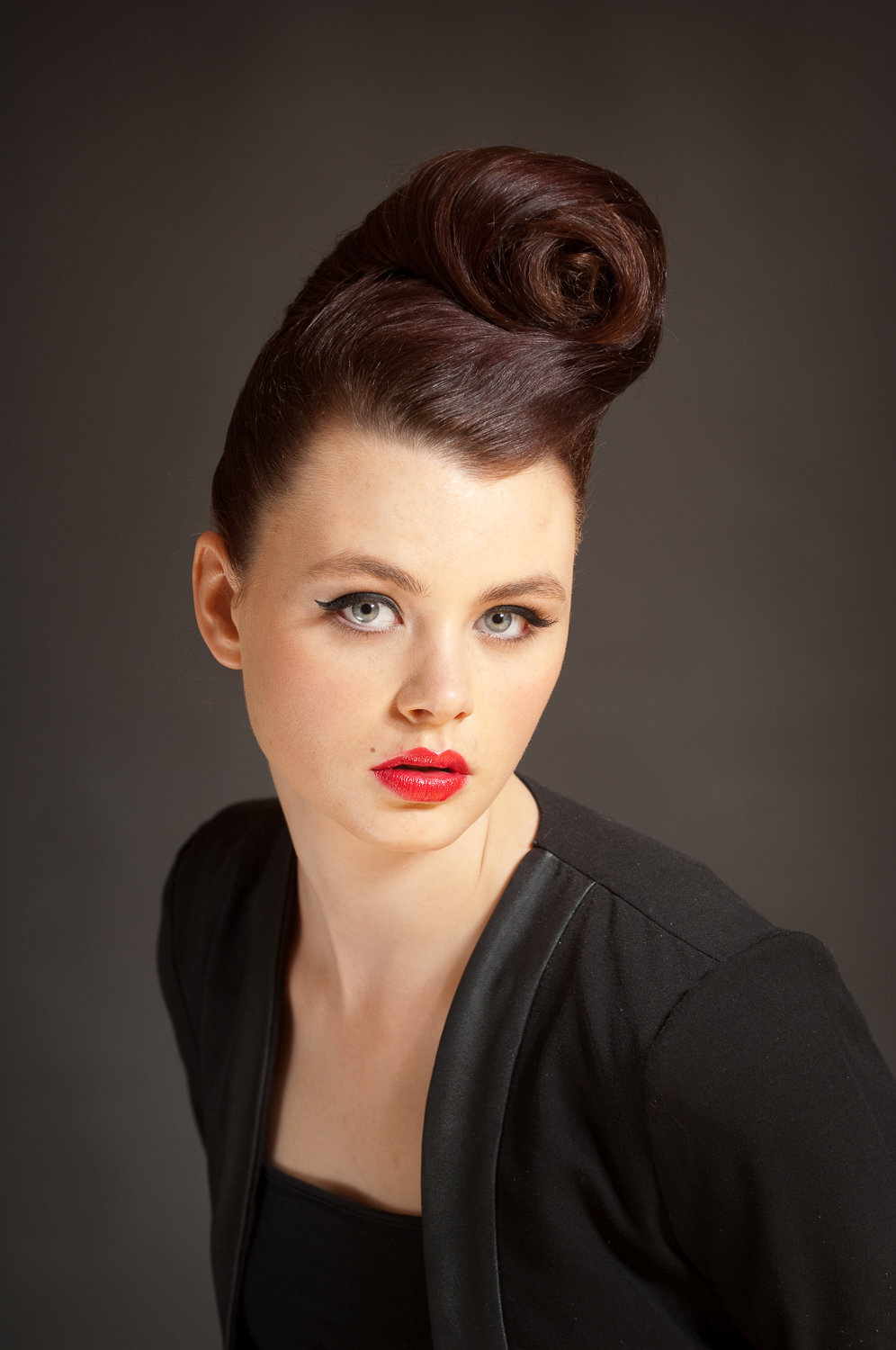 headshot of female model with vintage hairstyle, wearing black tuxedo jacket and red lipstick