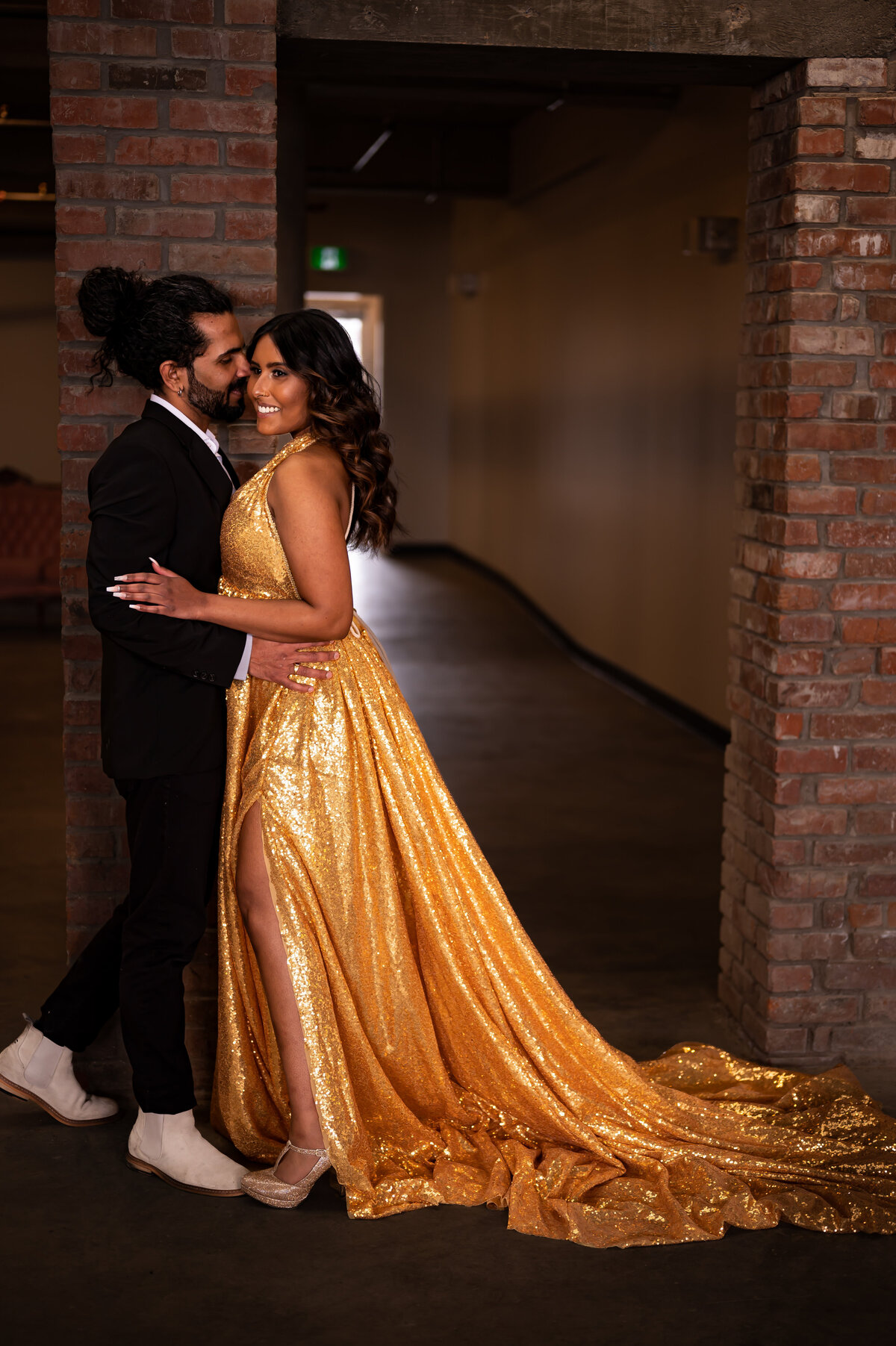 Engaged couple kissing in a warehouse brick building downtown edmonton