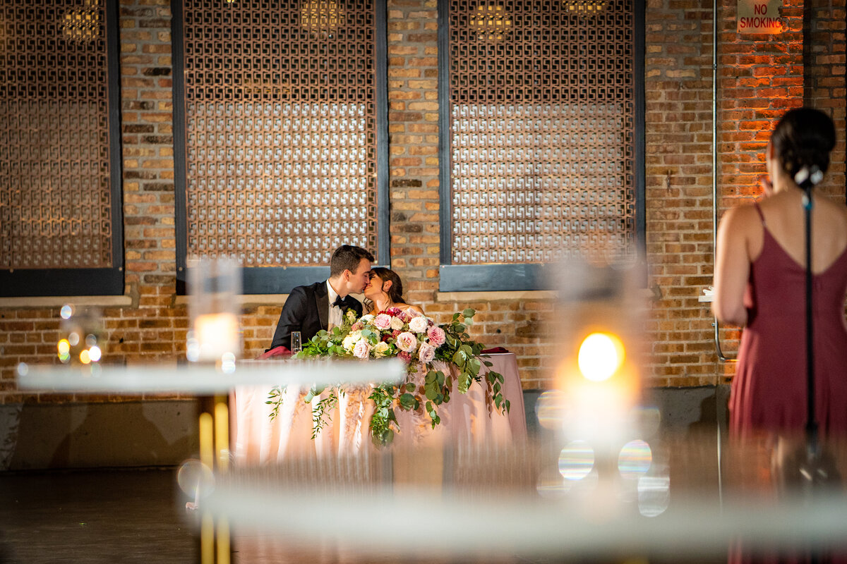bride and groom sitting at sweetheart table