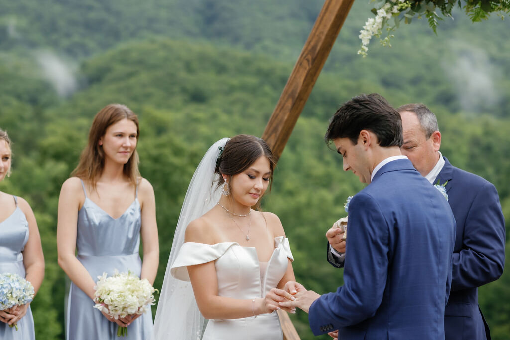 wedding photographers gatlinburg tn captures ring exchange between bride and groom at Mountain Mist Farms wedding venue 