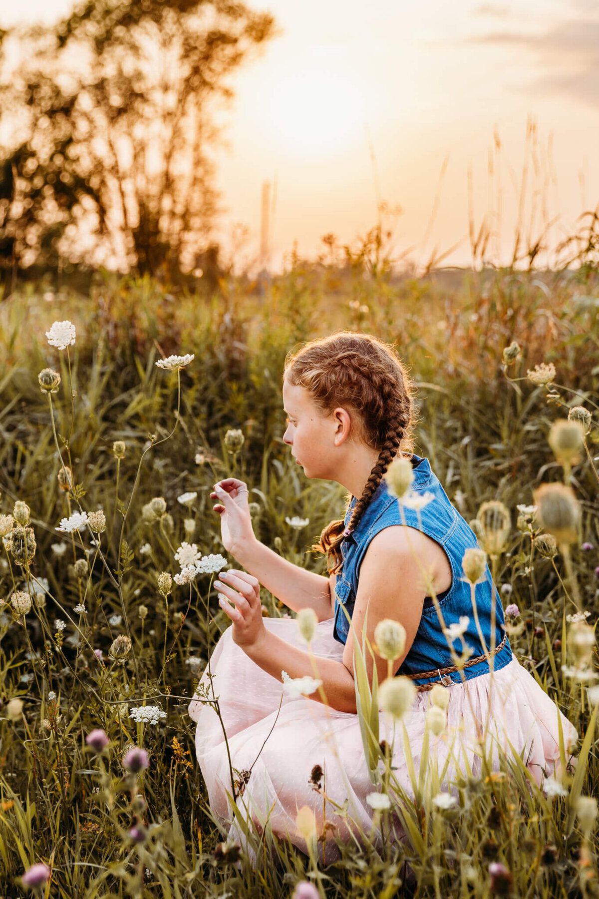 Young girl playing in the flowers at sunset just outside of Milwaukee.