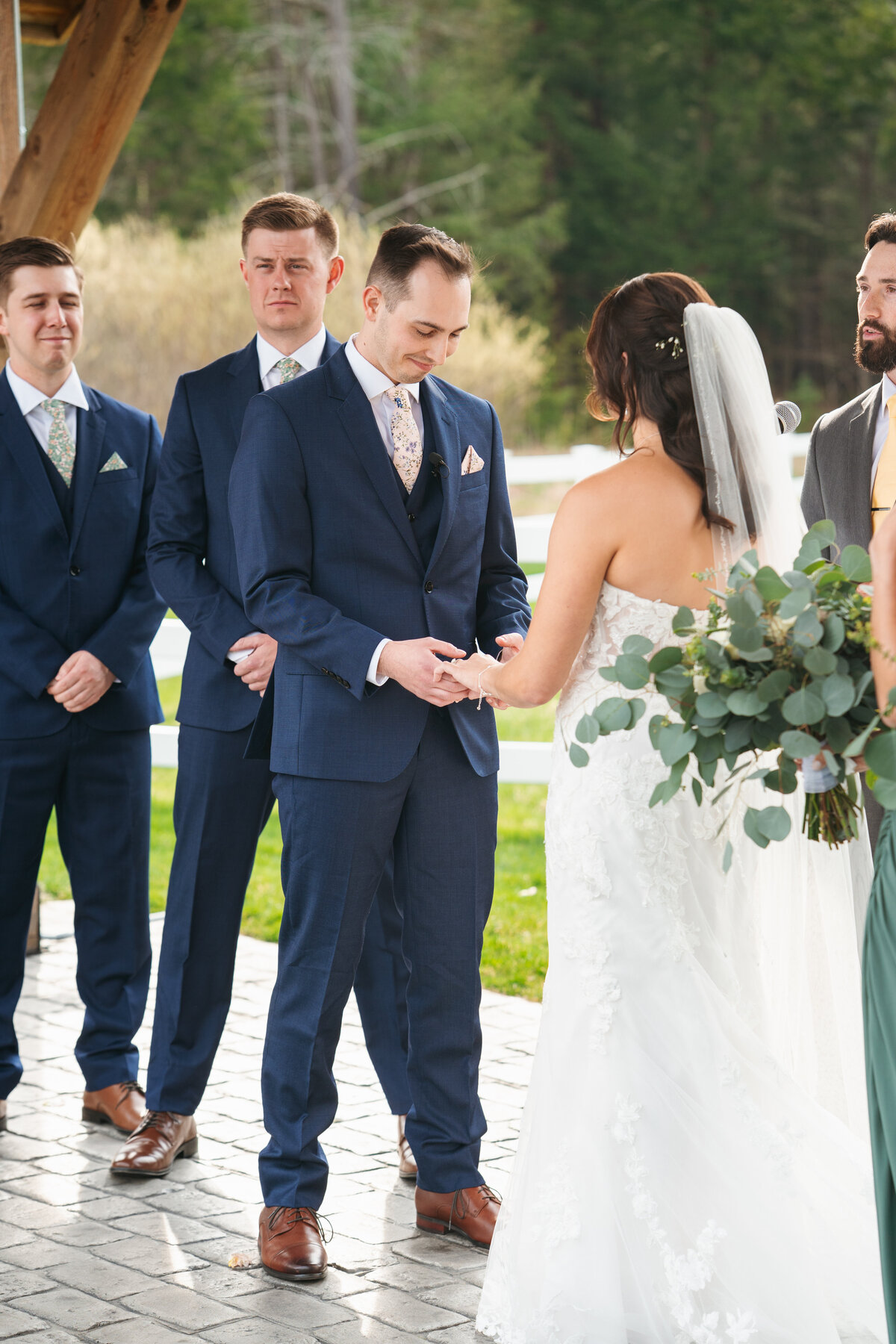 Couple exchanging vows under a floral arch in New England