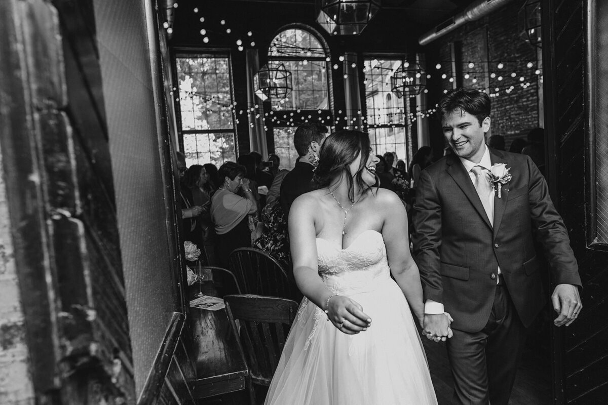 A couple holding hands as they walk out of their wedding ceremony 