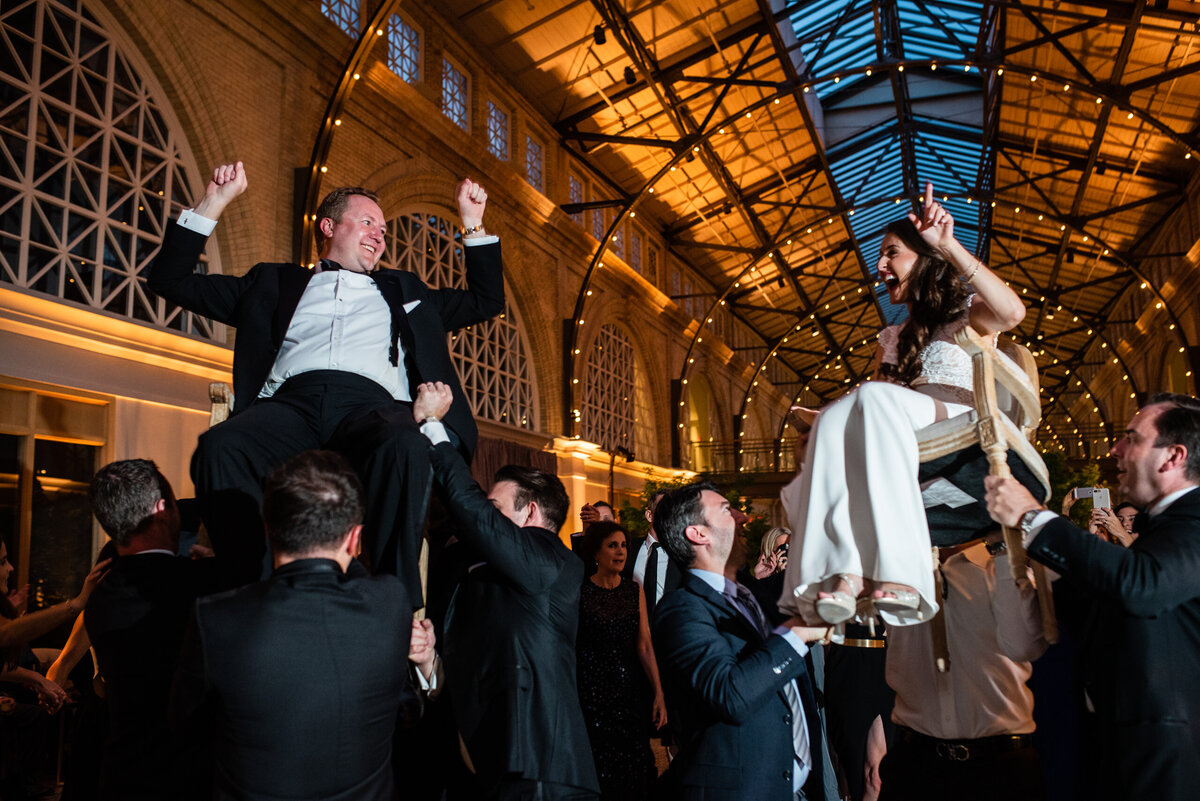 San Francisco wedding photographer captures Ferry Building reception with traditional chair dance ceremony