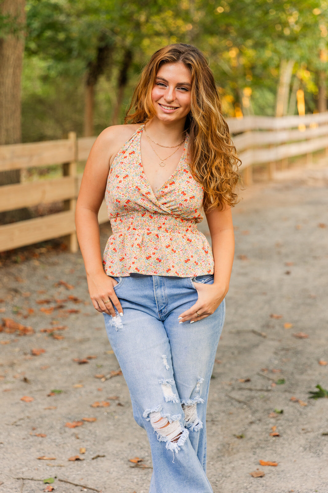senior looking at the camera  standing ankles crosses and hands in pockets during senior photo session
