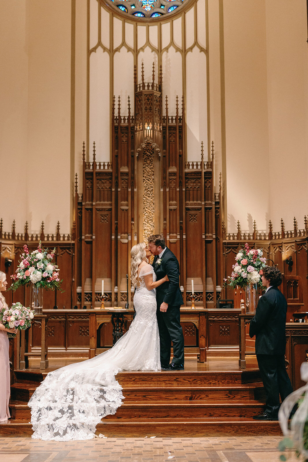 First kiss at Memorial Presbyterian Church in St. Louis, with the brides lace train dripping down the stairs