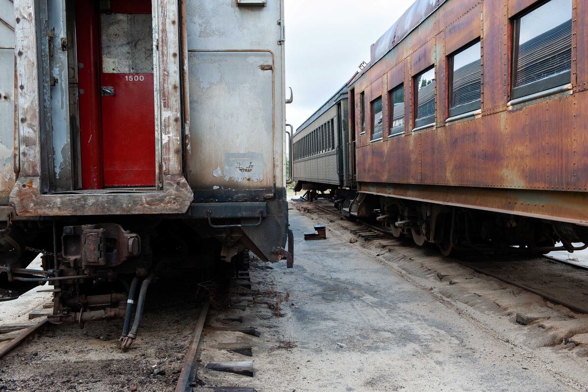 A red doo and rusted train car with step stool