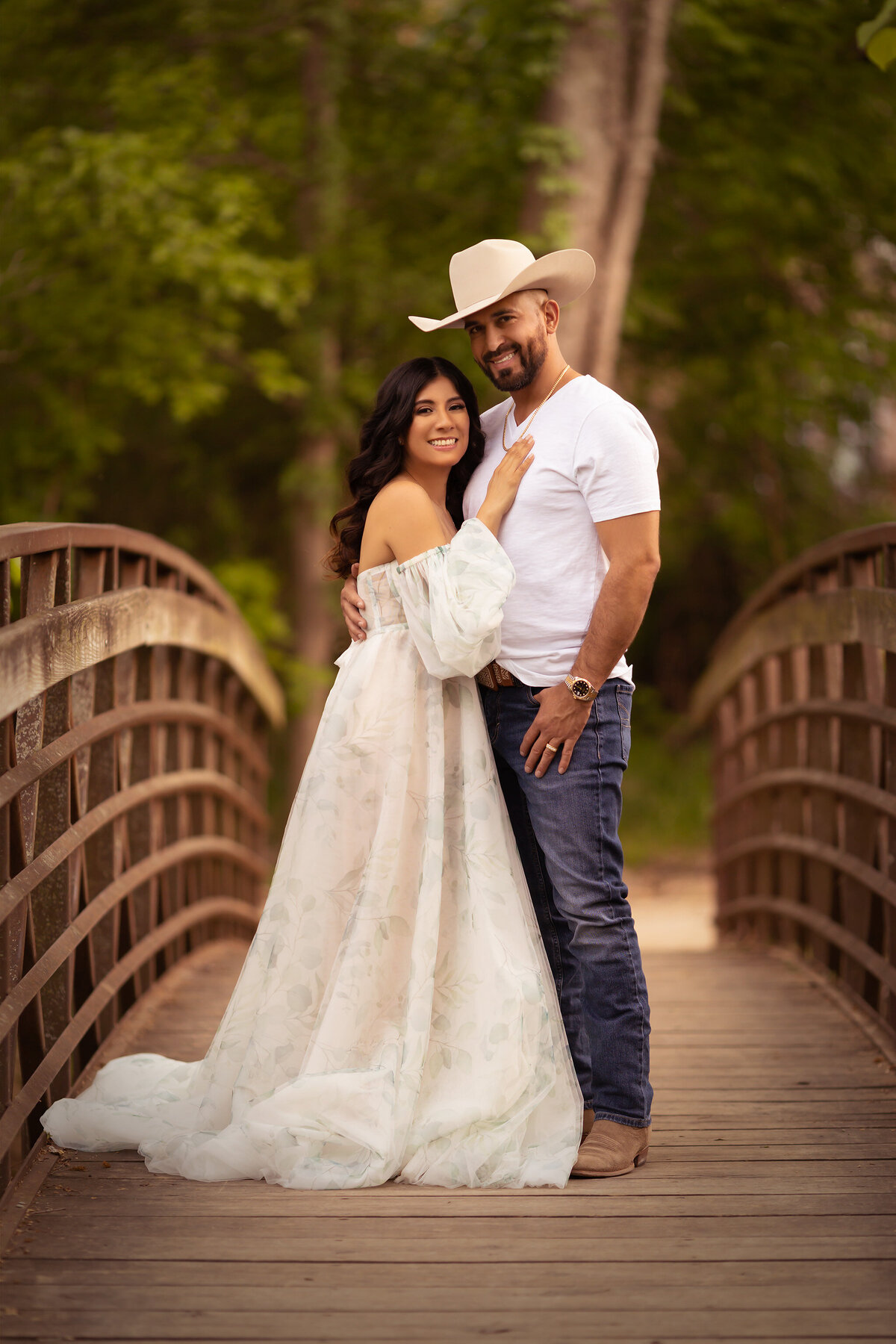 A couple embraces on a bridge during a Dallas family portrait session, showcasing Dallas family photography in the beautiful outdoors.
