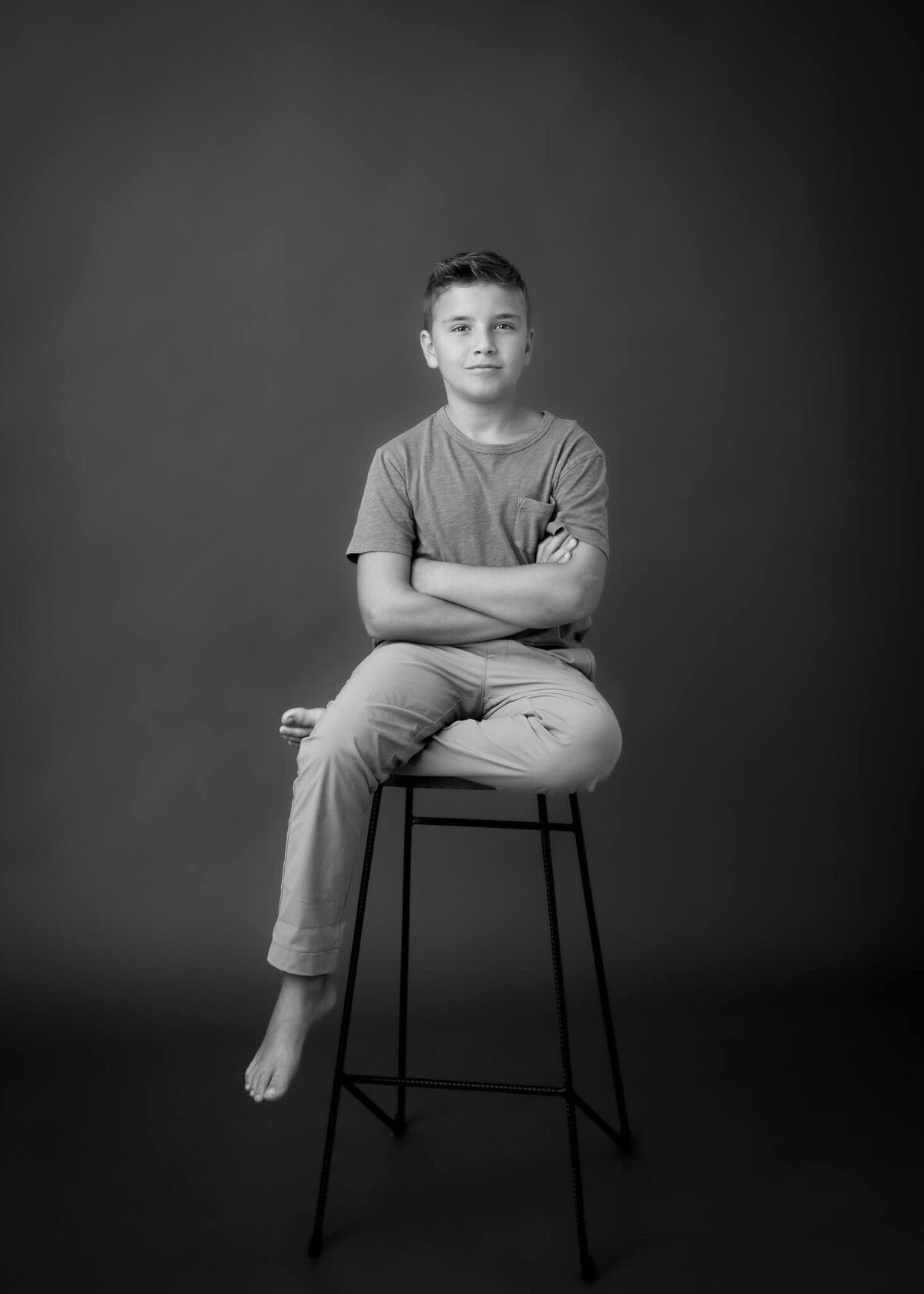 10 year old boy on stool in captivating black and white studio portrait