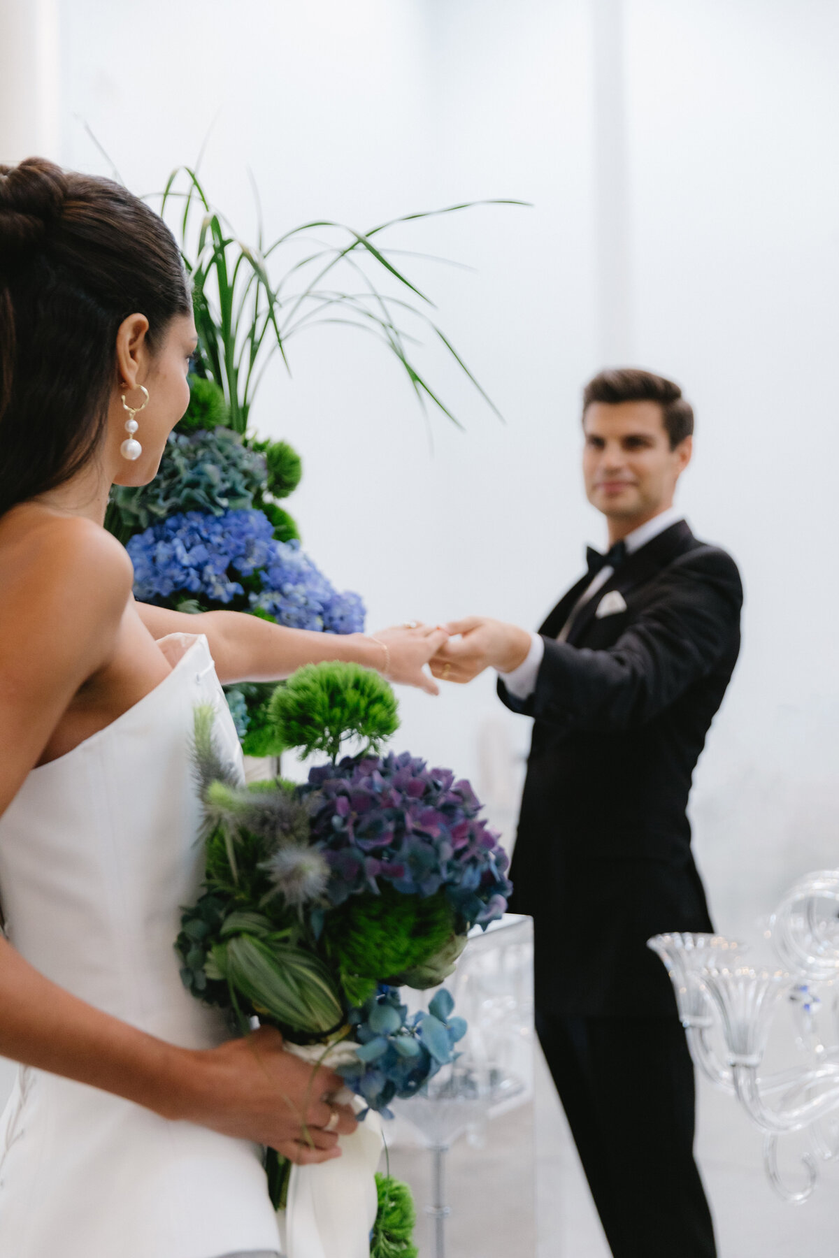 Couple holding hands and posing in a bright, minimalist ceremony setup at Sound River Studios in New York City.