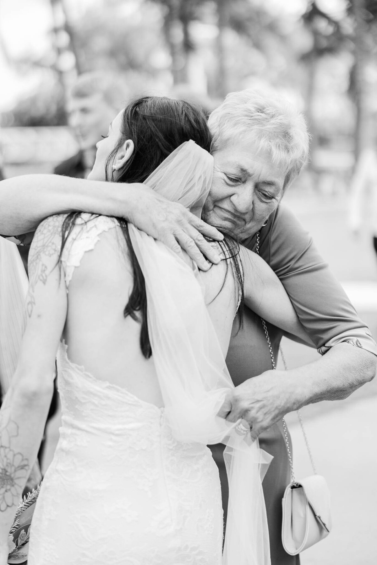emotional grandma hugs her granddaughter on  her wedding day.