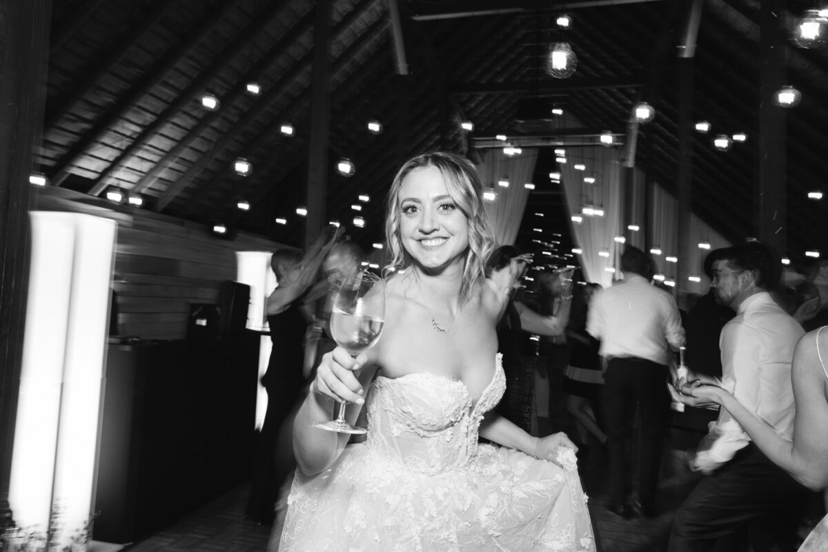 Bride dancing holding wine glass at wedding reception at Barn 8