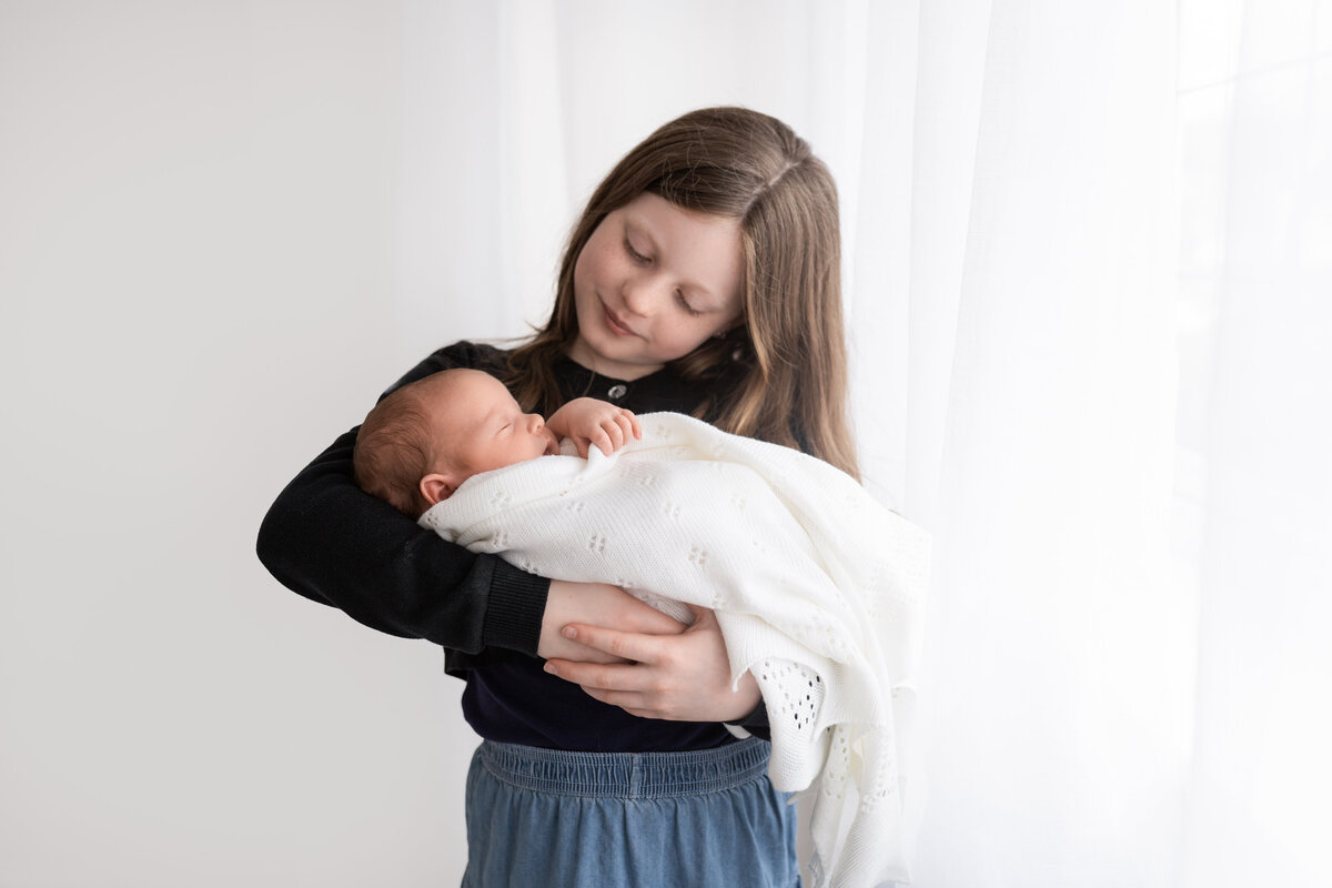 OLder sister with Newborn sibling in Natural style