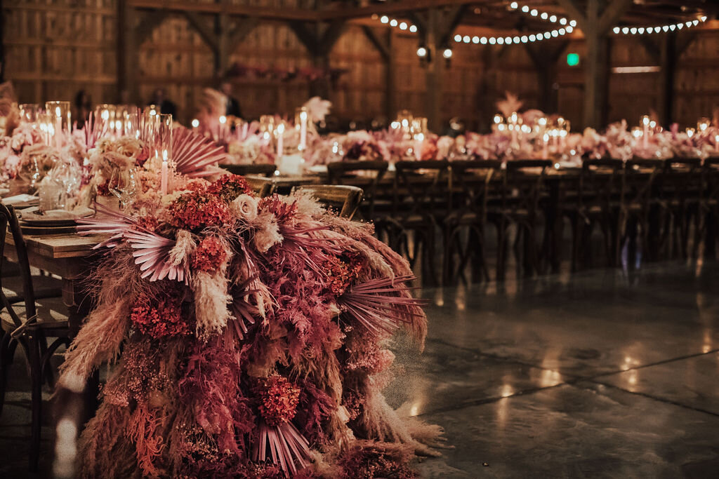 Elegant barn wedding with farm table and white and pink taper candles