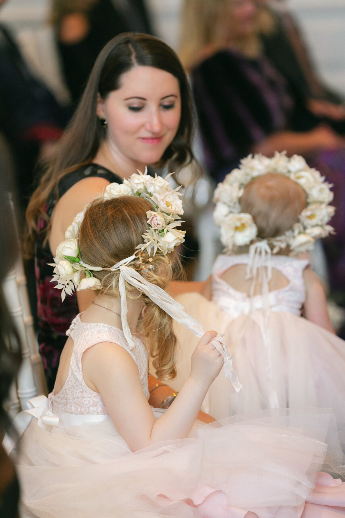 close up of flower girls during the wedding ceremony in the Governor’s Room at The Adolphus in Dallas, highlighting their floral wreaths and dresses in a charming and elegant moment.